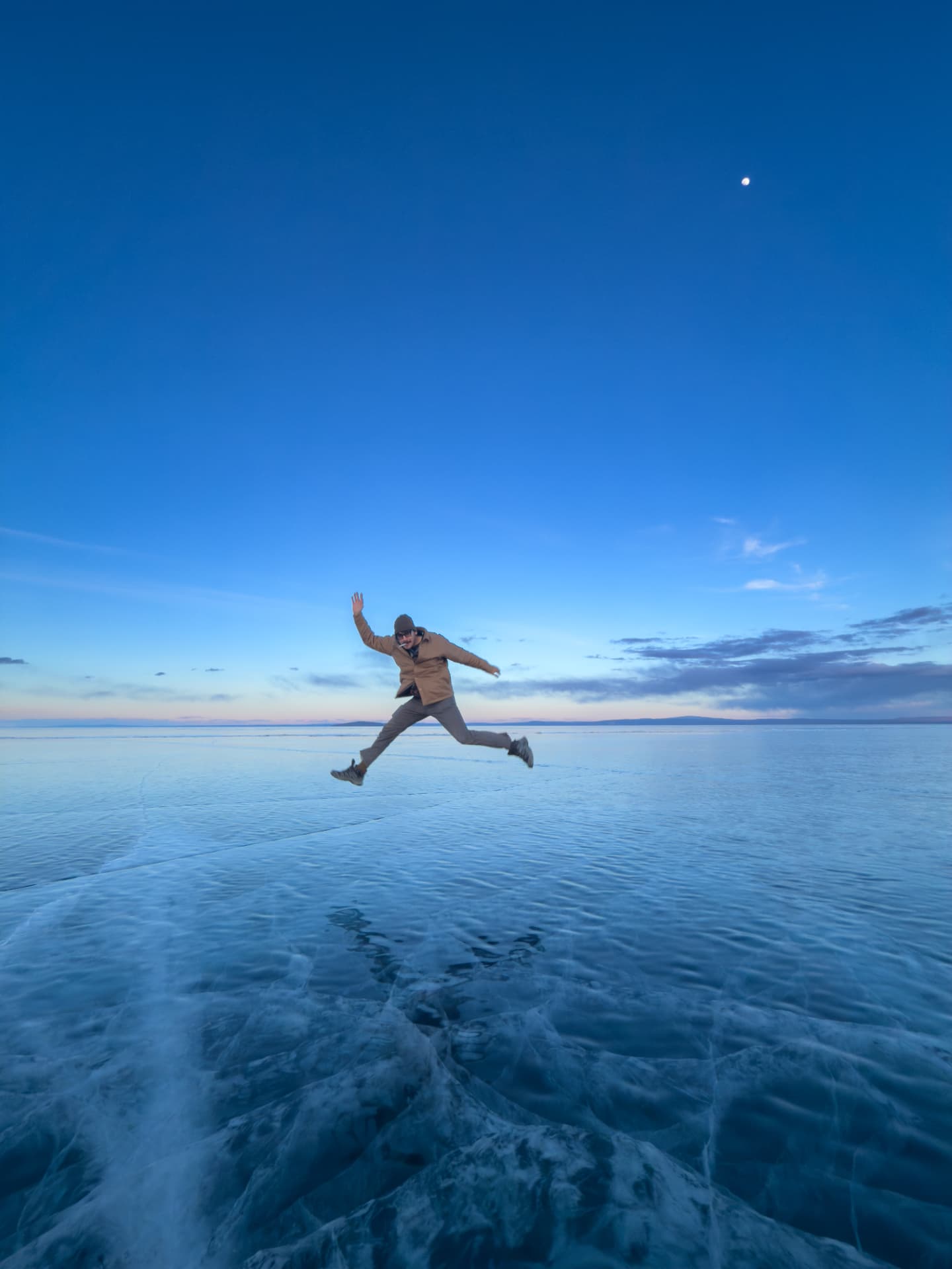 Jason jumping above the clear blue ice of frozen Lake Khövsgöl